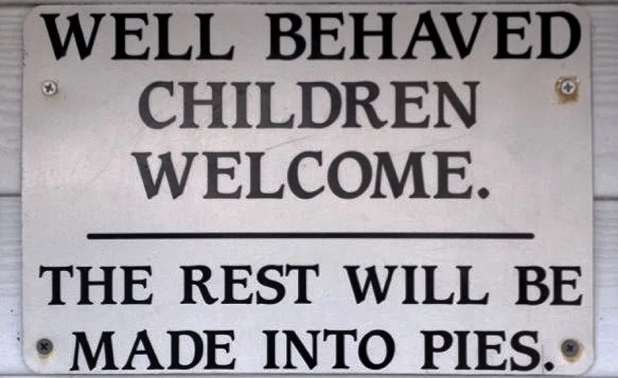 Wooden sign outside Marion's Pie Shop reading: Well behaved children welcome, the rest will be made into pie
